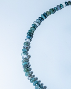 Necklace with blue and green beaded chain on a white background