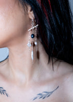 Close-up of a person wearing a unique earring with beads.