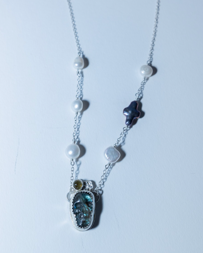 Necklace with gemstone pendant and pearls on a white background