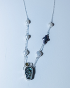 Necklace with gemstone pendant and pearls on a white background