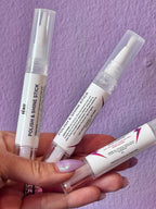 Hand holding three small POLISHING tubes with labels on a purple textured background FOR JEWELRY CLEANING 