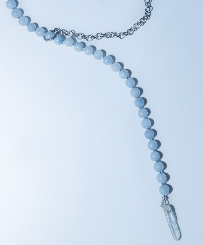 Necklace with blue beads and a crystal pendant on a light blue background