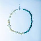 Beaded necklace with blue and multicolored beads on a light blue background