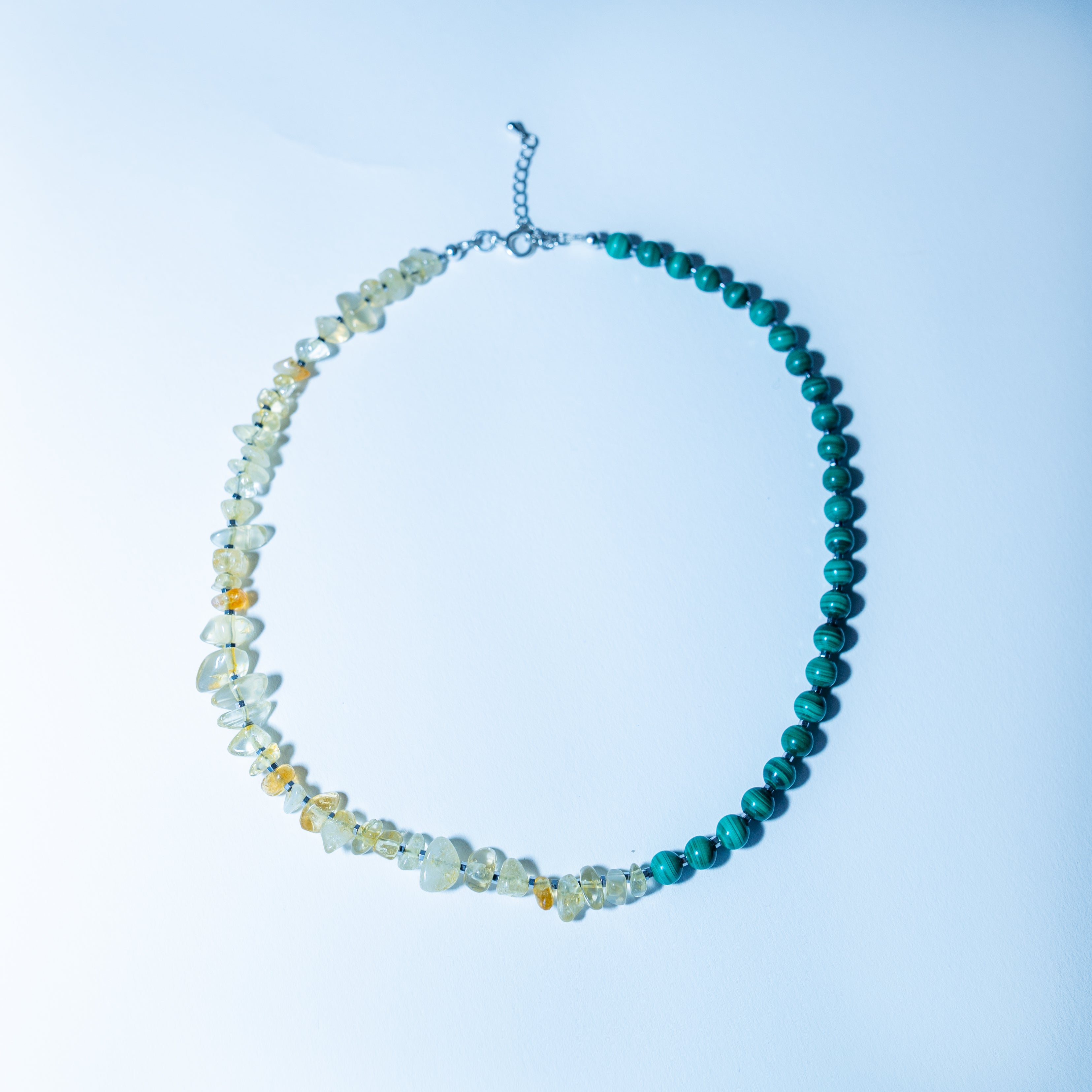 Beaded necklace with blue and multicolored beads on a light blue background