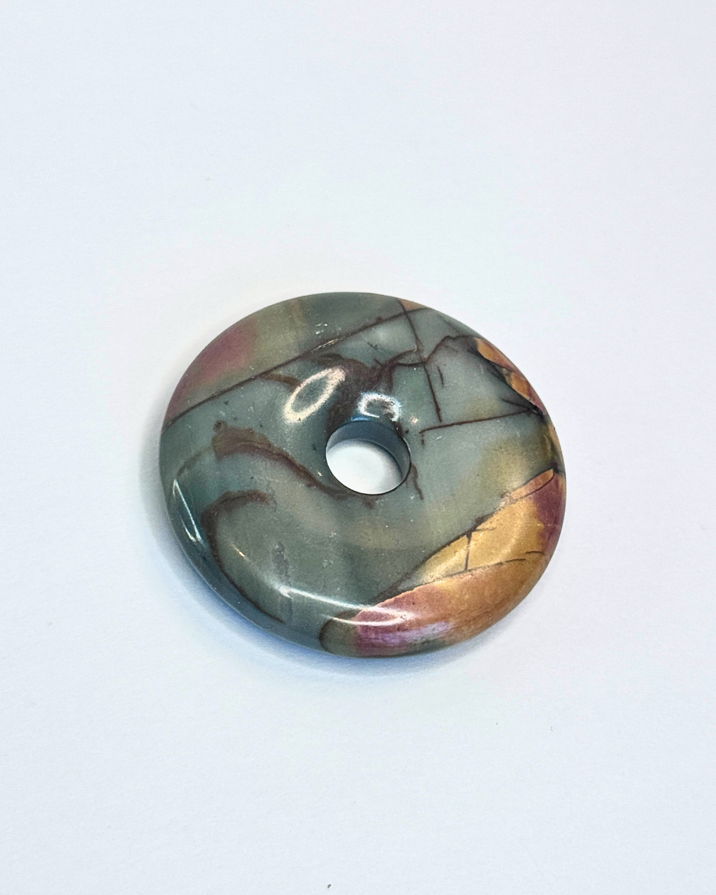 Round stone with marbled pattern on a white background