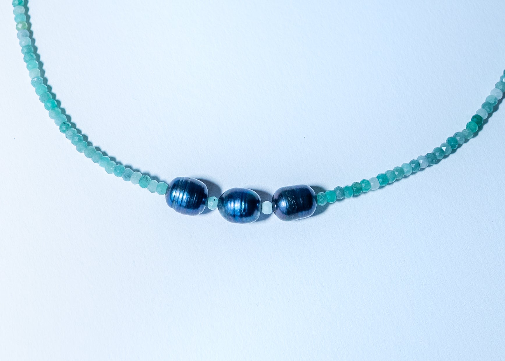 Necklace with blue beads on a light blue background
