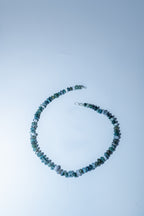 Necklace with blue beads on a light blue background