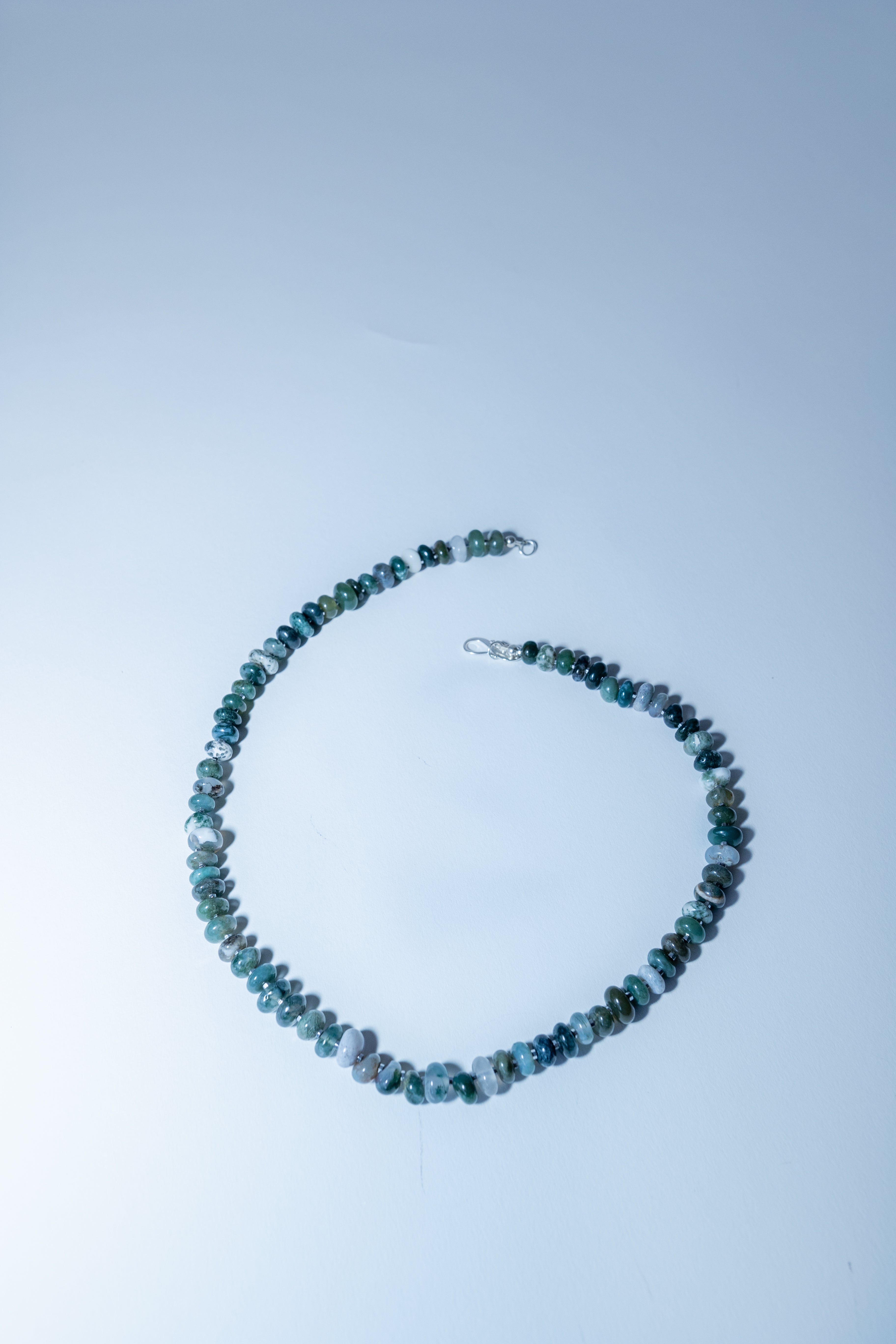 Necklace with blue beads on a light blue background