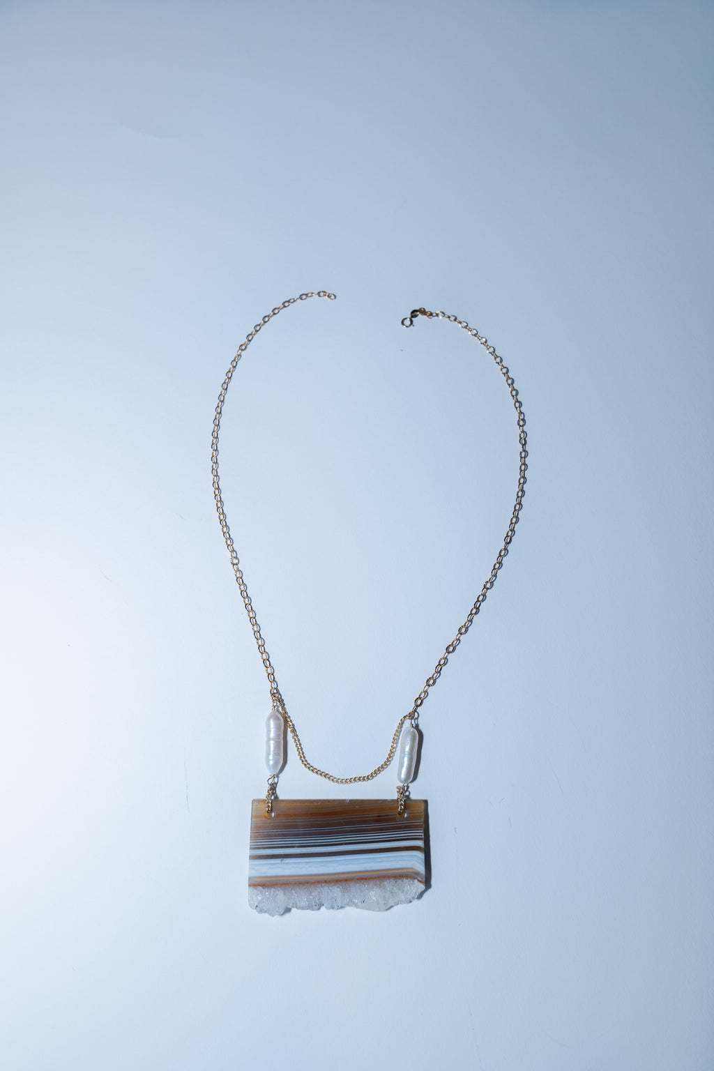 Necklace with a rectangular pendant on a light blue background