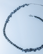 Necklace with black beads on a light blue background