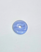 Blue marbled donut-shaped object on a light gray background