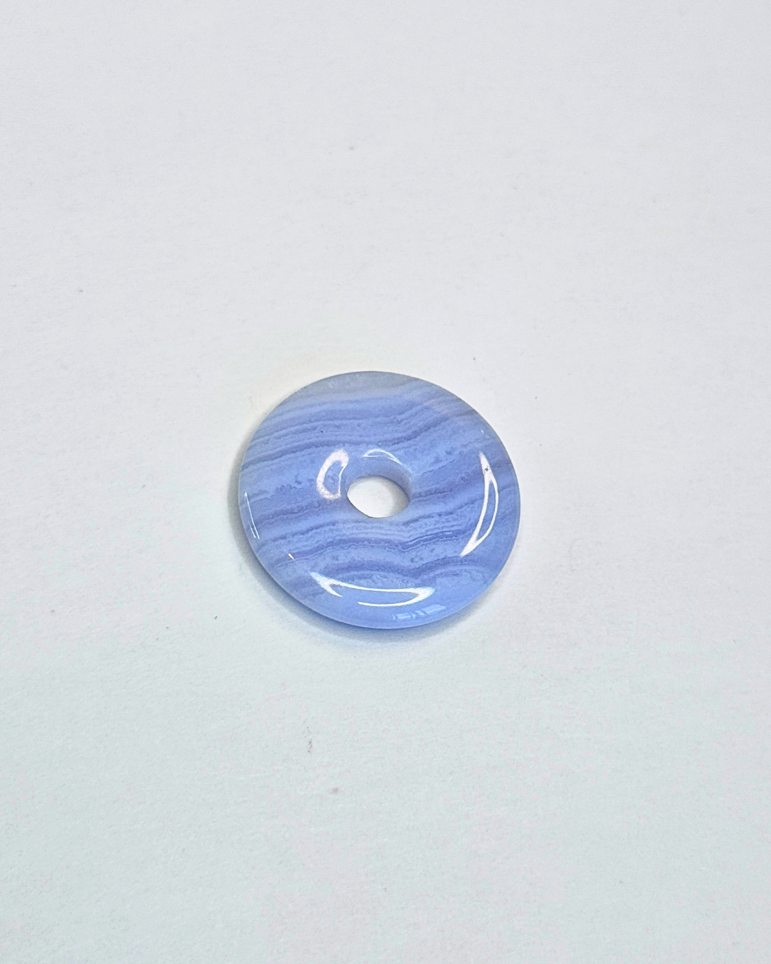 Blue marbled donut-shaped object on a light gray background