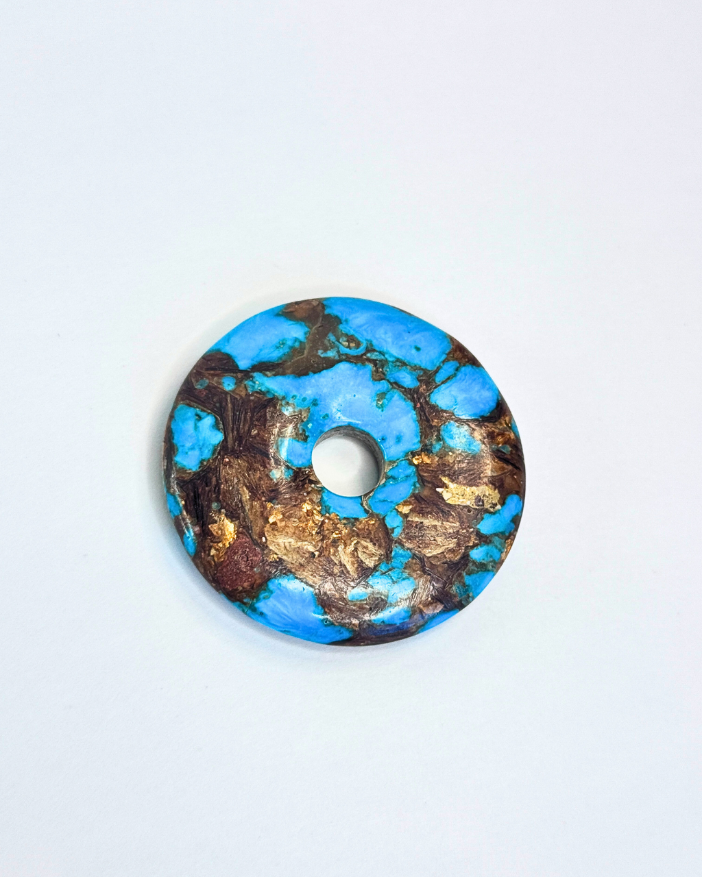 Decorative circular object with blue and gold design on a white background