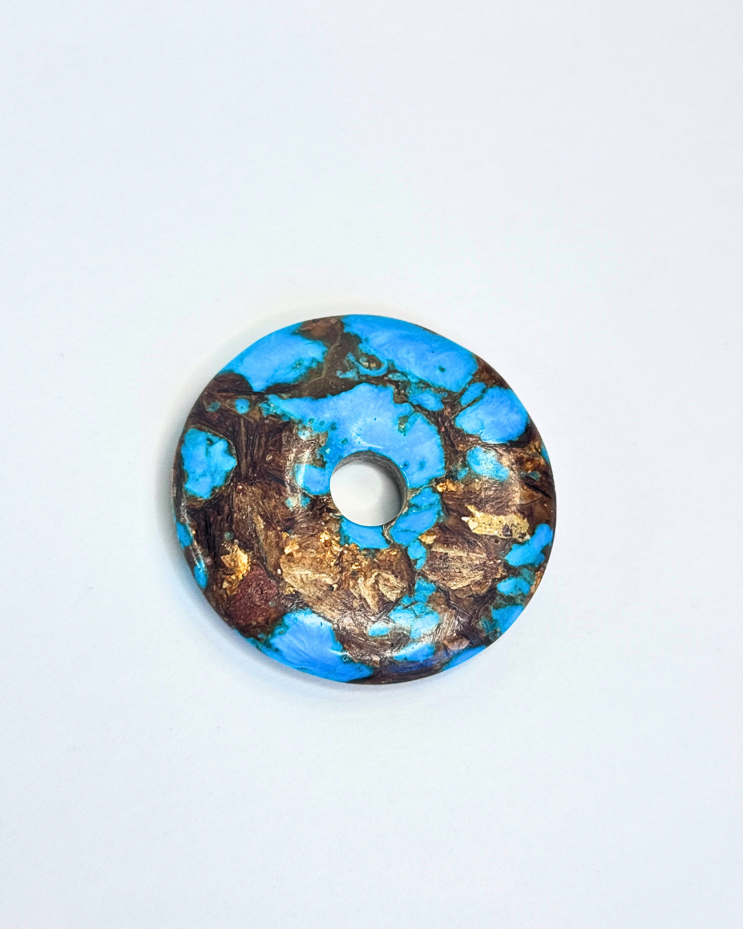 Decorative circular object with blue and gold design on a white background