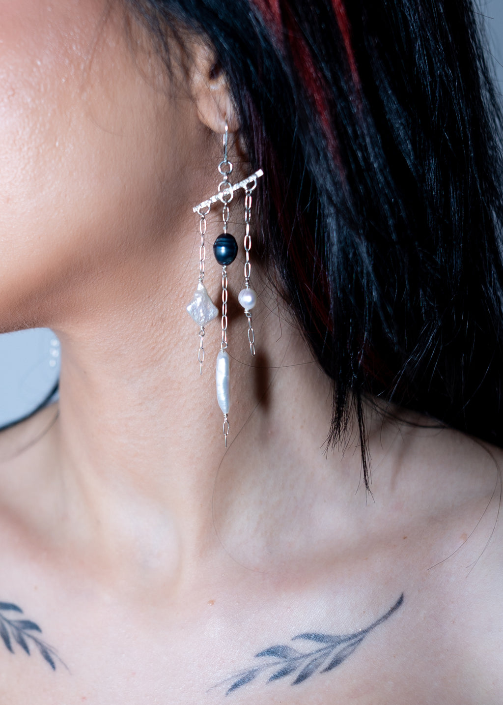 Close-up of a person wearing a unique earring with beads.