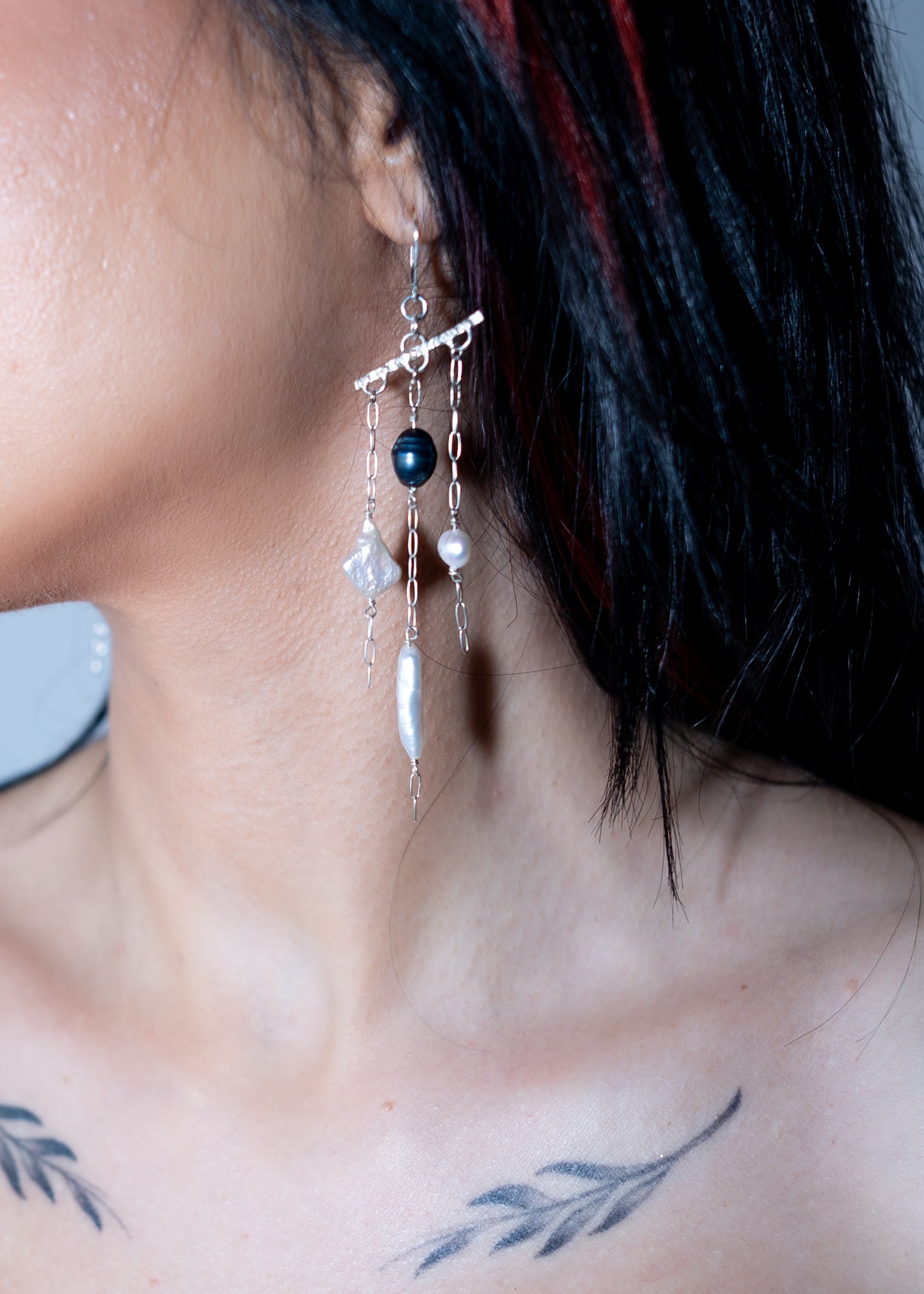 Close-up of a person wearing a unique earring with beads.