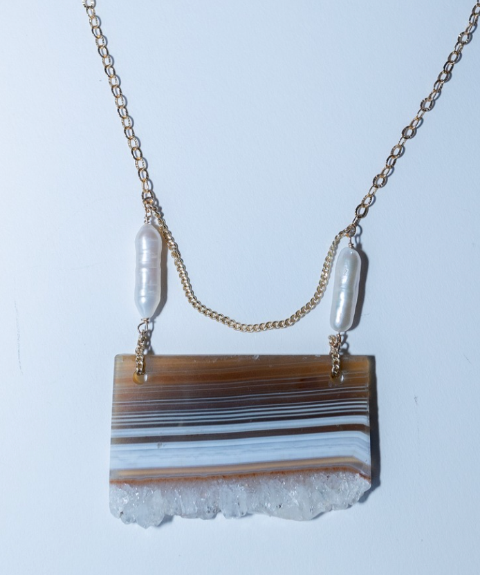 Necklace with a rectangular stone pendant on a light blue background