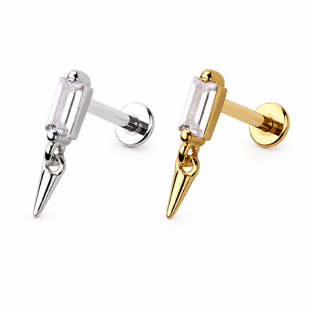 Two gothic-style stud earrings with a clear rectangular crystal and a dangling pointed spike charm, shown in silver and gold finishes on a white background.