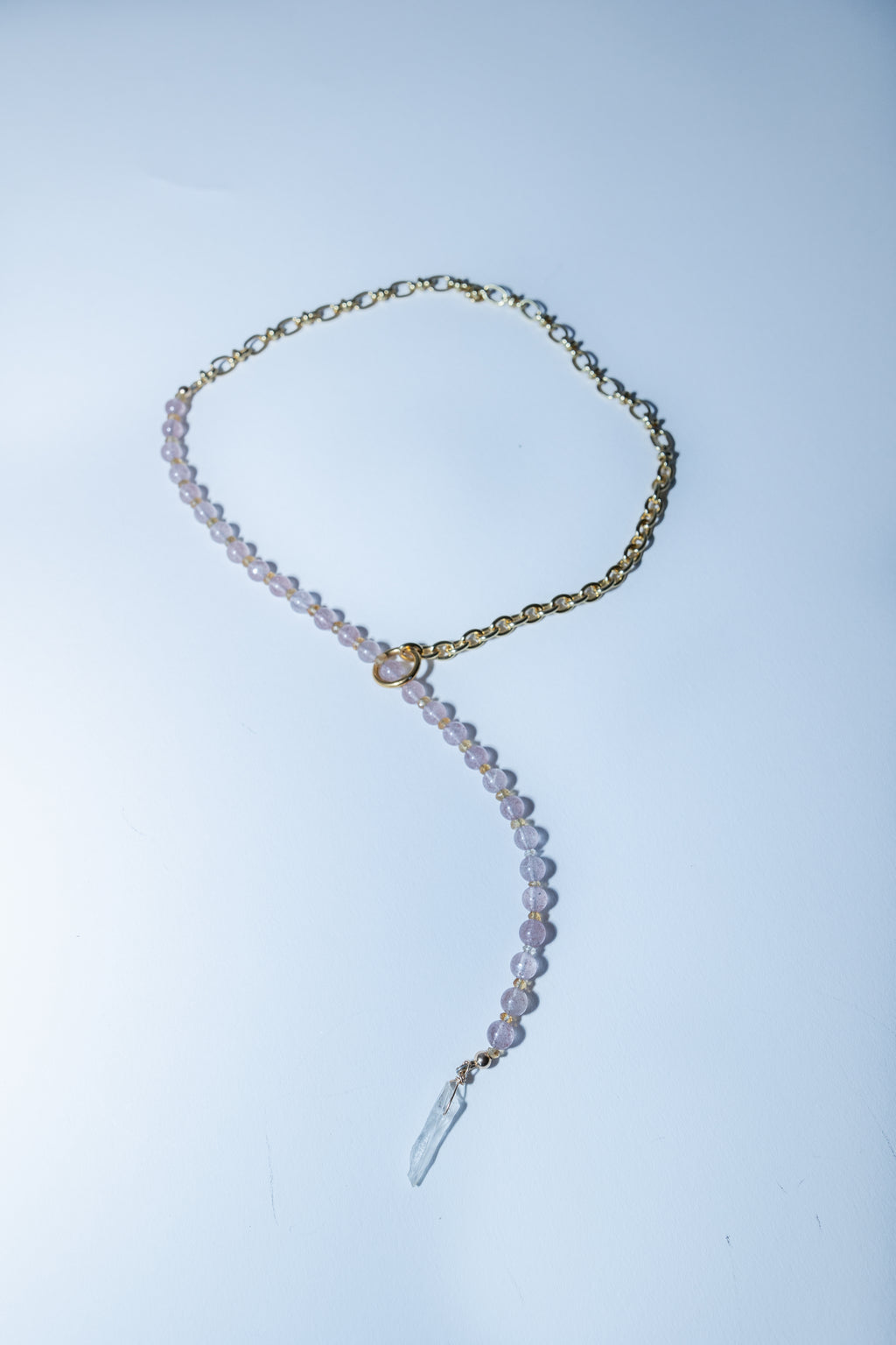 Necklace with clear pendant on a light blue background