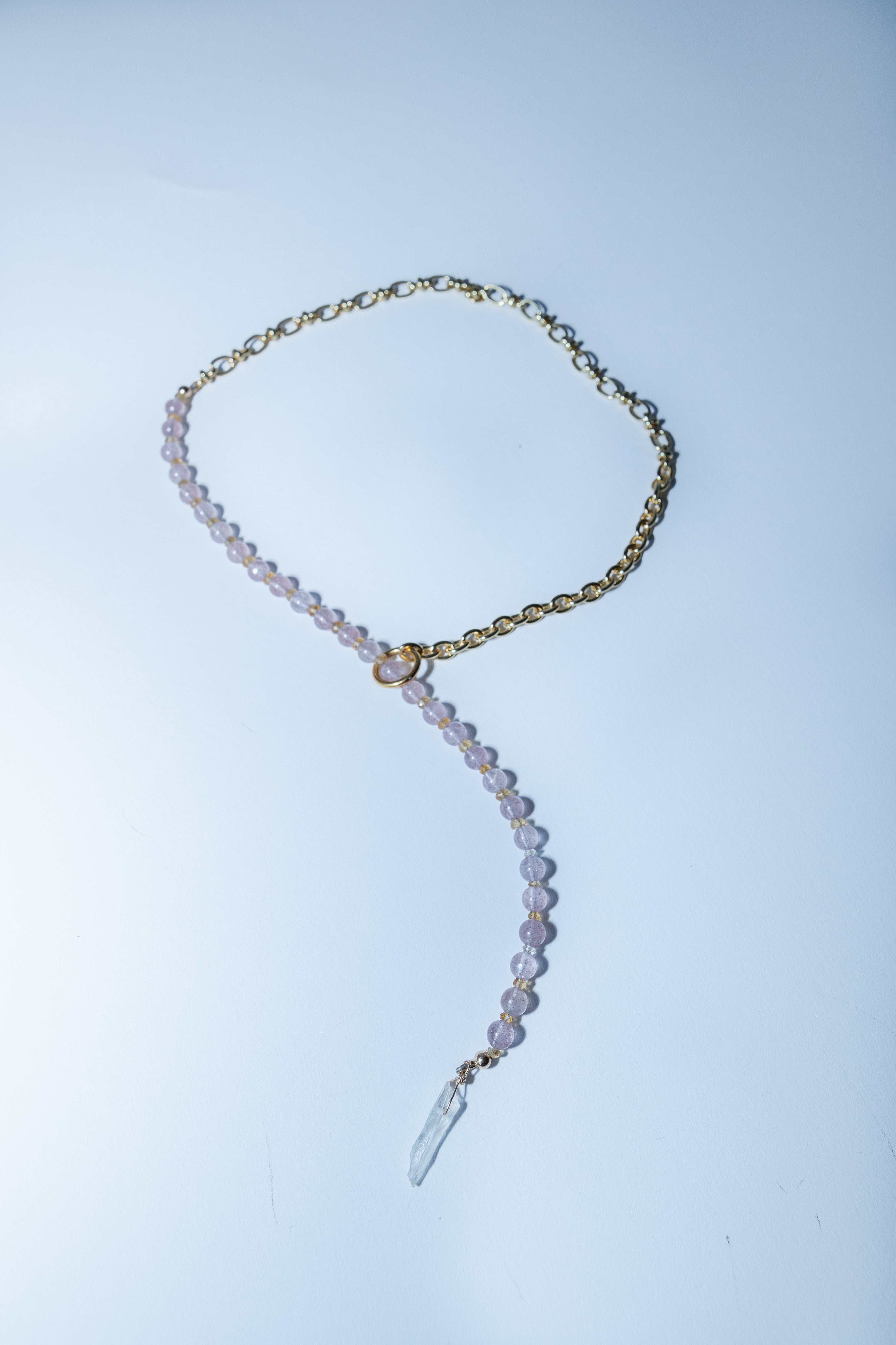 Necklace with clear pendant on a light blue background