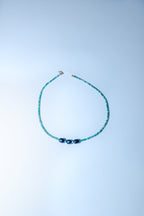 Beaded necklace on a light blue background