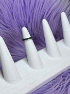 Ring on a white mannequin hand against a purple fur background