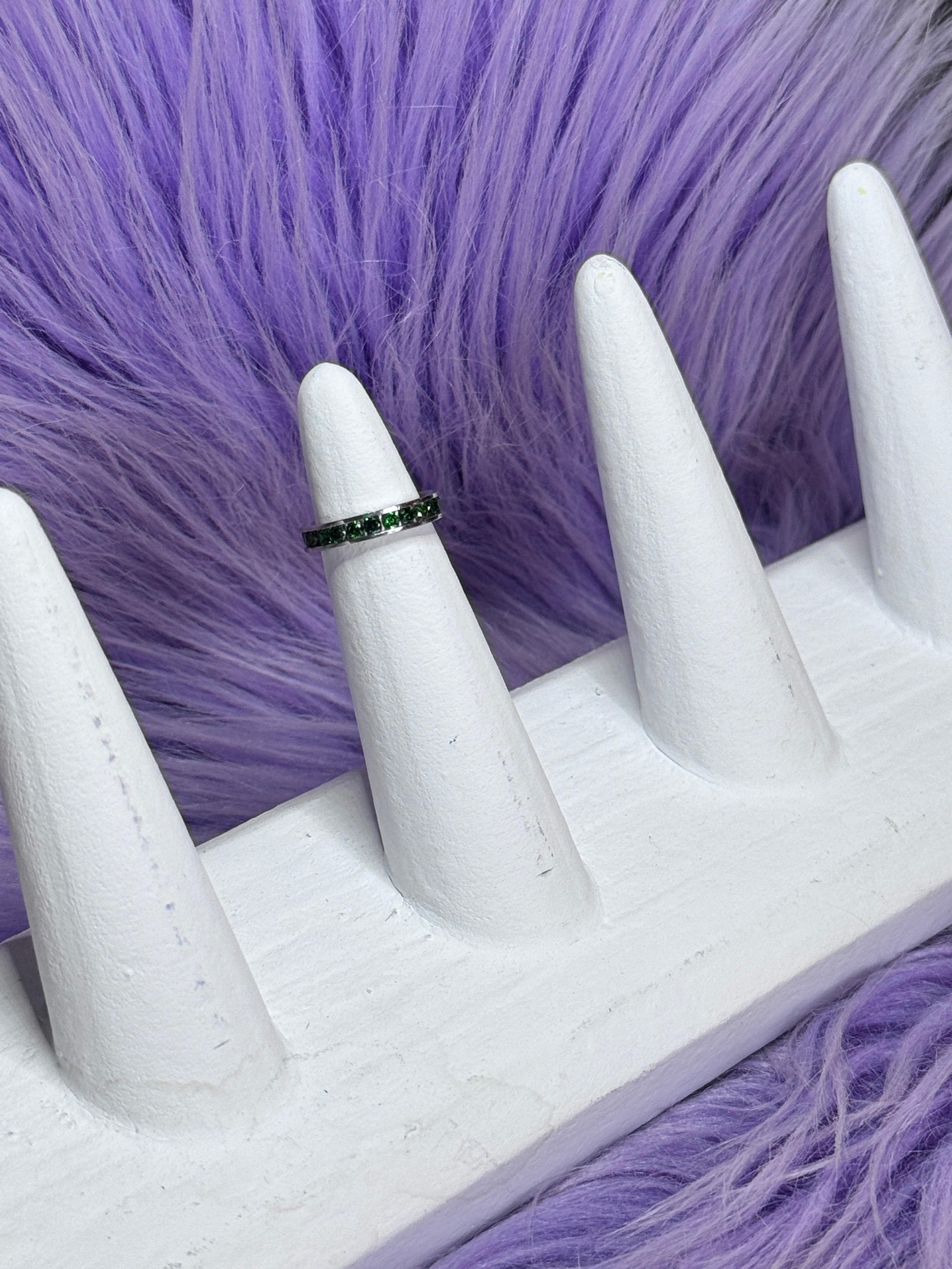 Ring on a white mannequin hand against a purple fur background