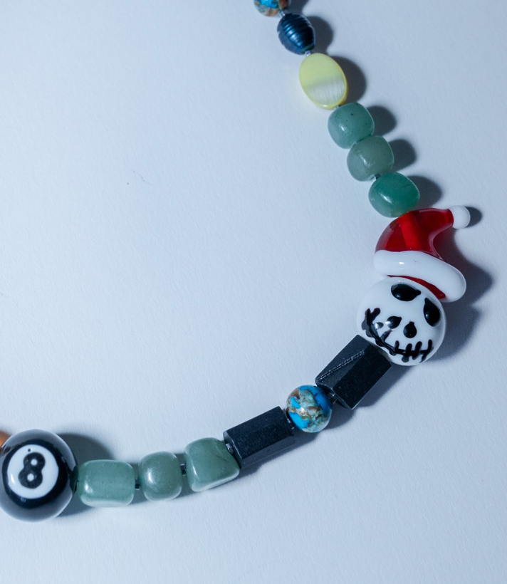 Colorful beaded necklace with a skull design on a white background