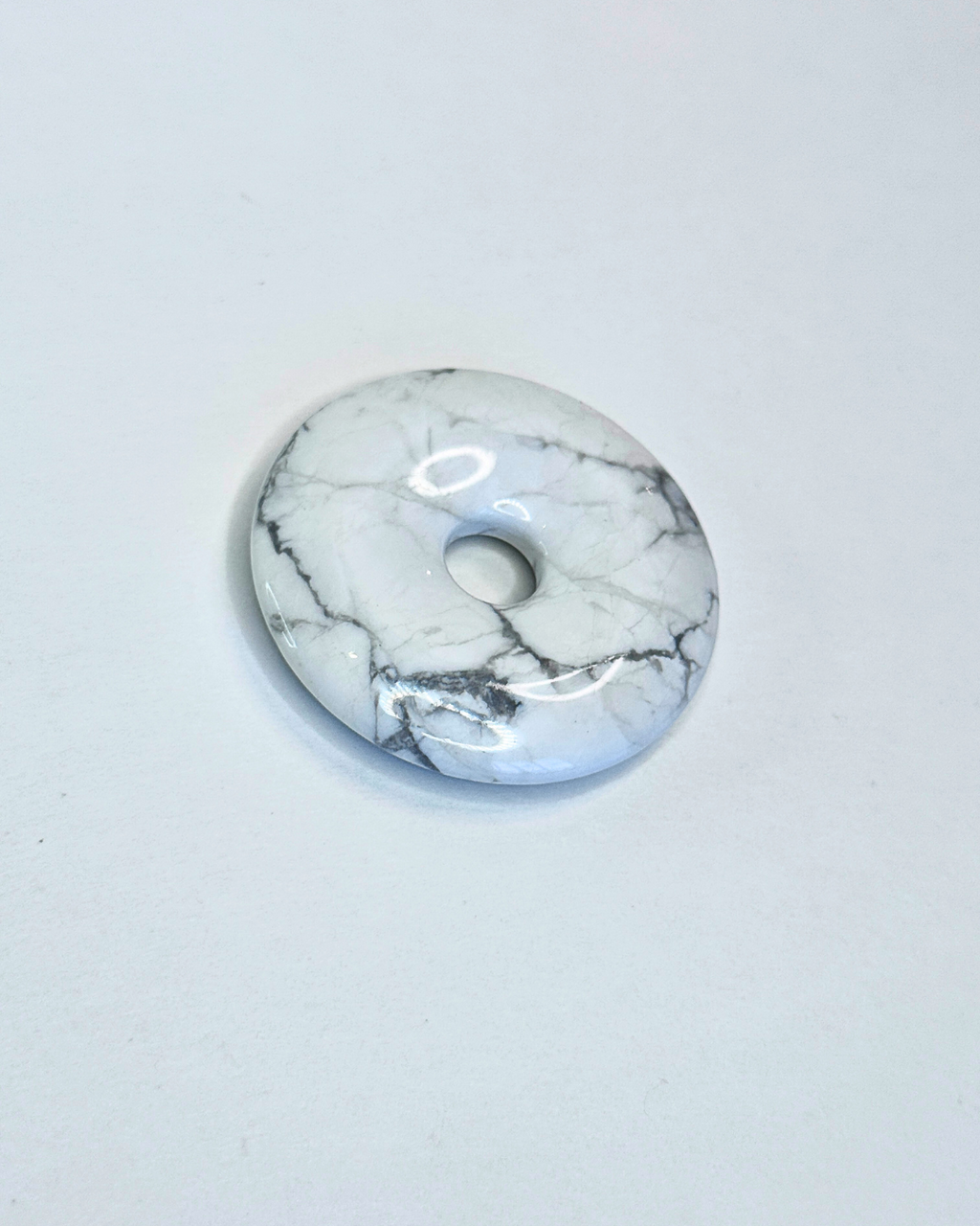 Marble-patterned donut-shaped object on a light gray background