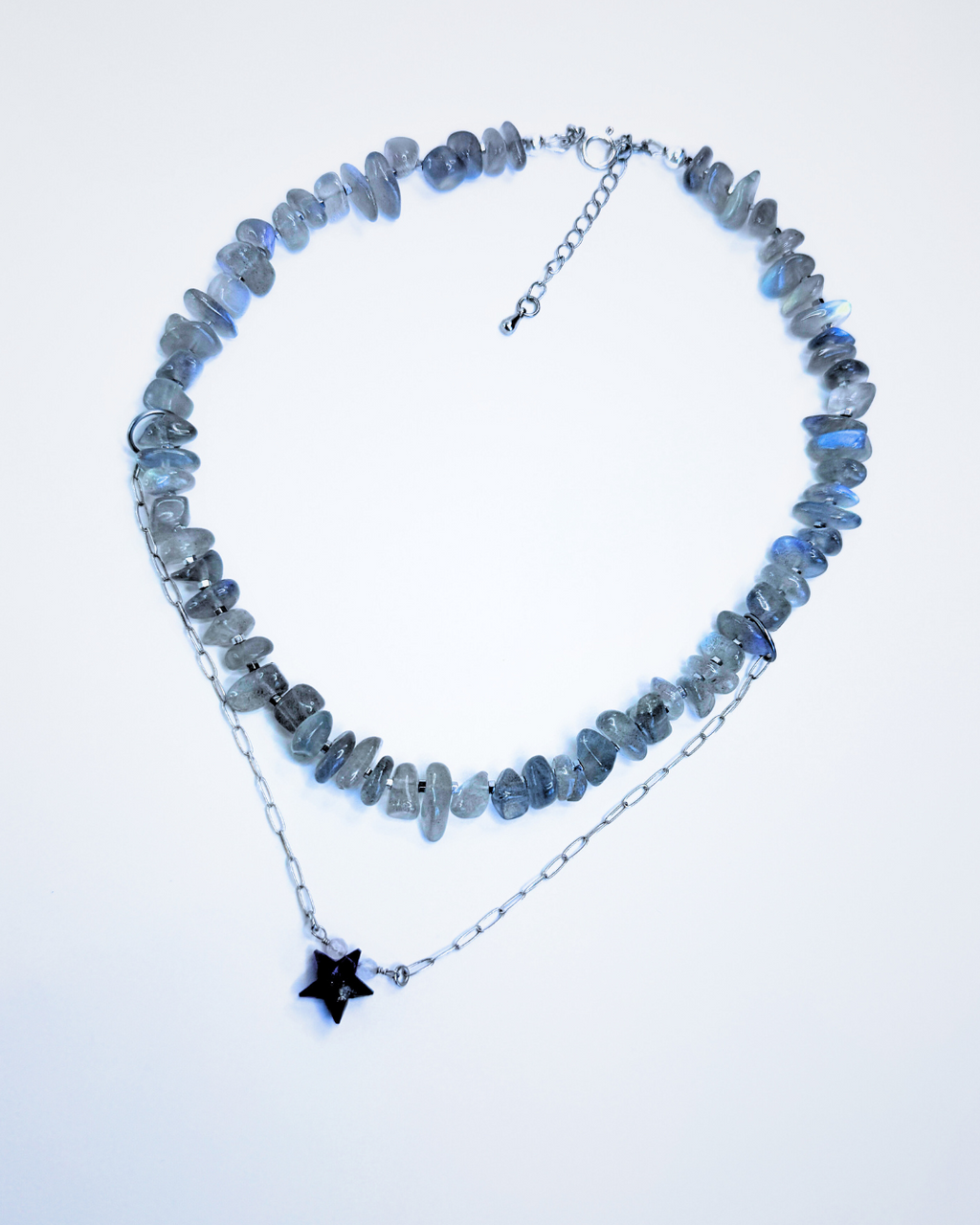Necklace with blue stone beads and a star-shaped pendant on a light blue background