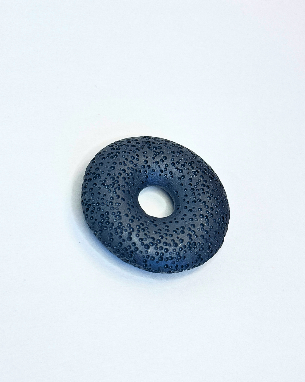 Black donut-shaped object on a white background