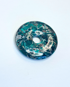 Decorative donut with green and gold marbled pattern on a white background