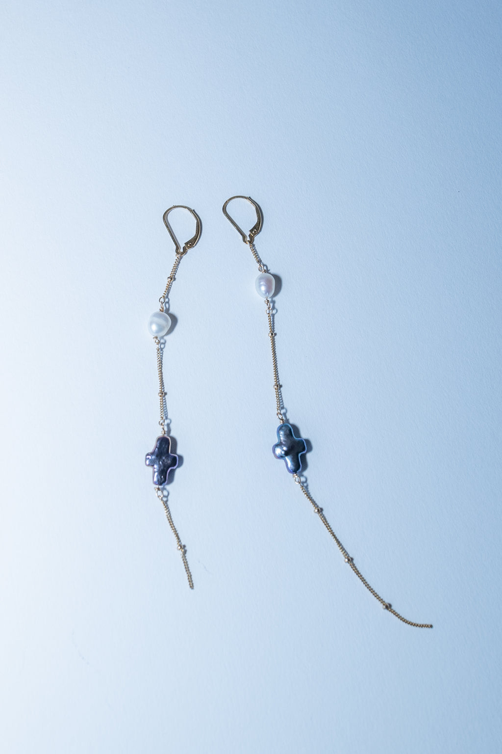 Pair of beaded earrings on a light blue background
