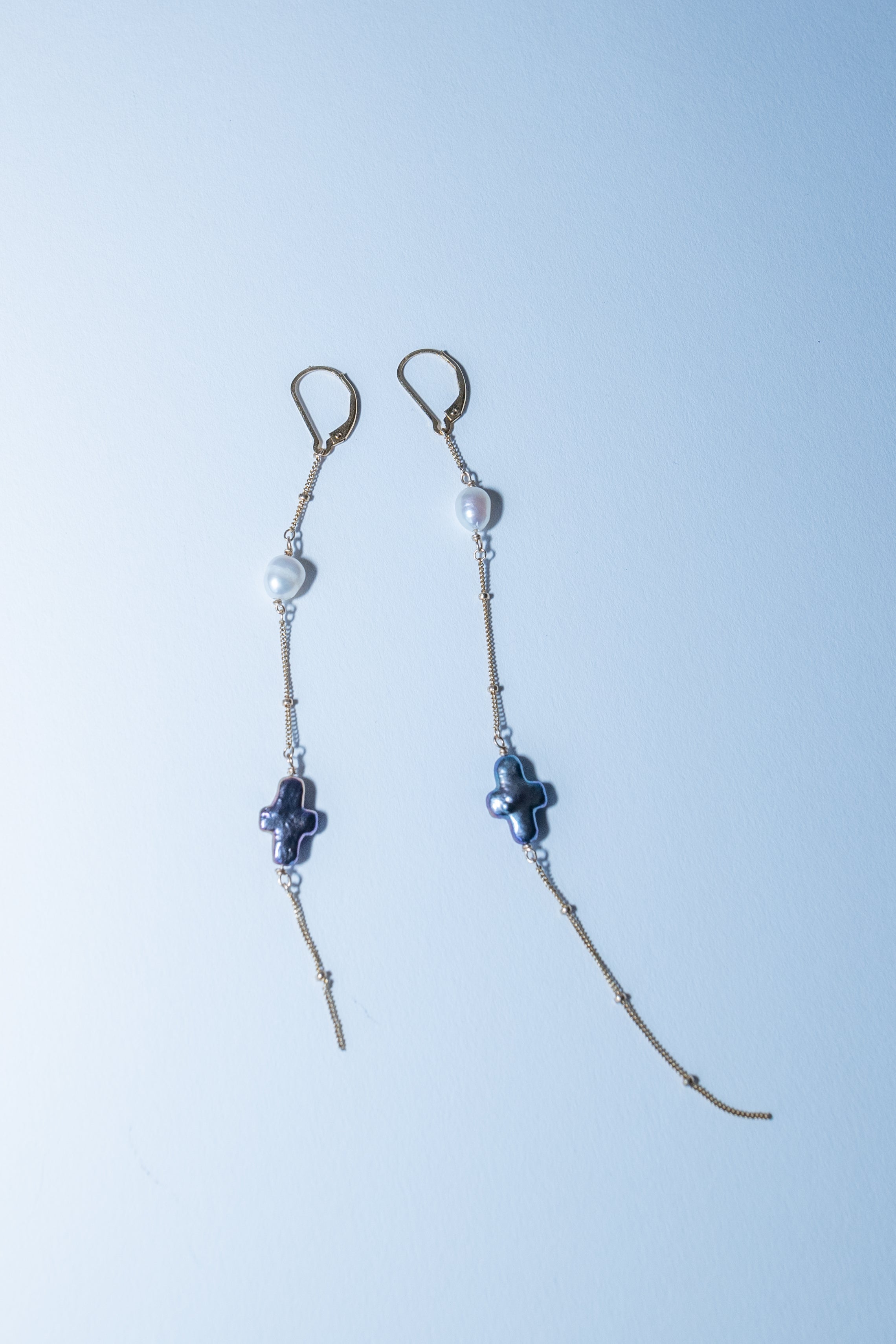 Pair of beaded earrings on a light blue background