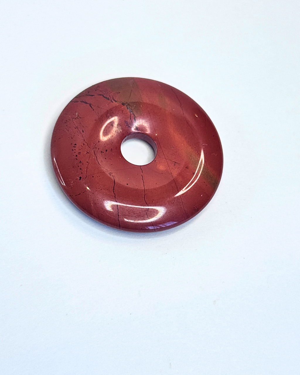 Red donut-shaped object on a white background