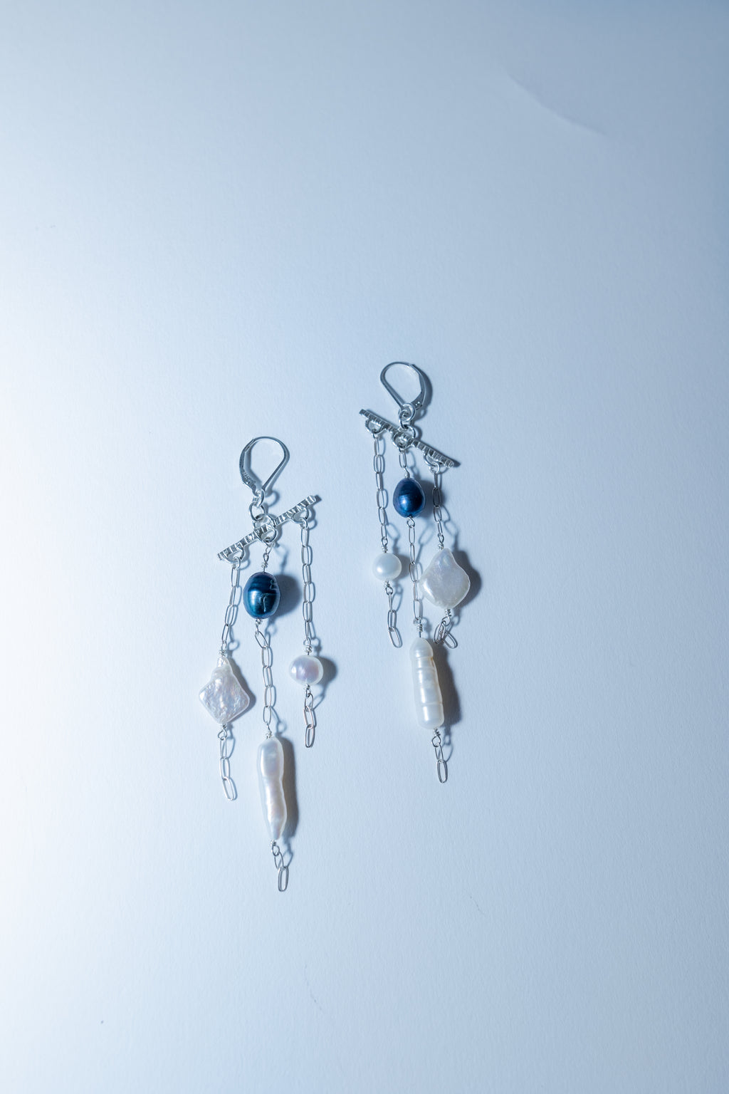 Pair of earrings with beads on a light blue background