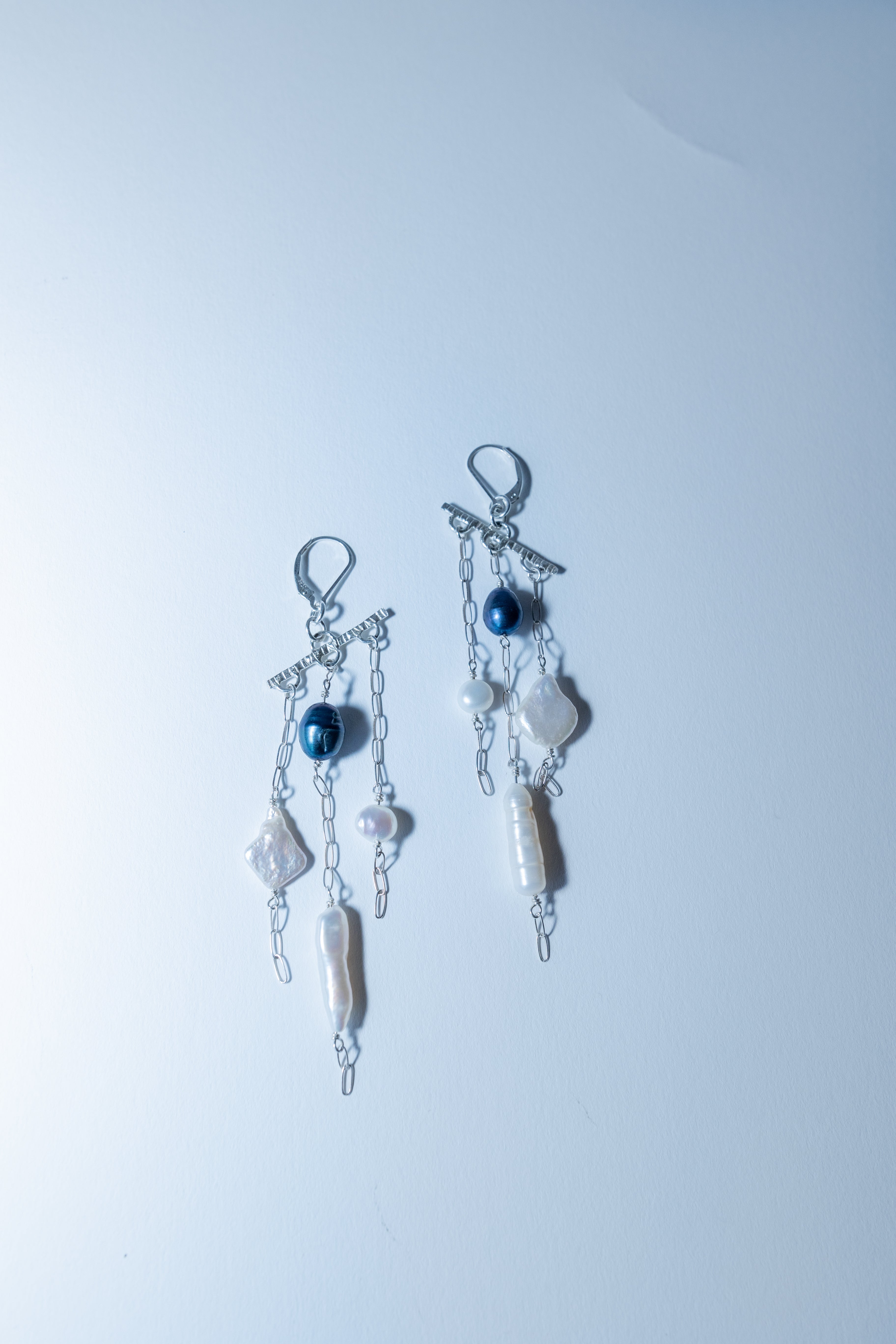Pair of earrings with beads on a light blue background