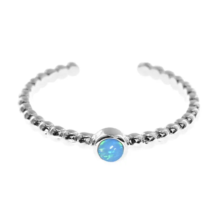 Silver toe ring with a blue opal stone on a white background