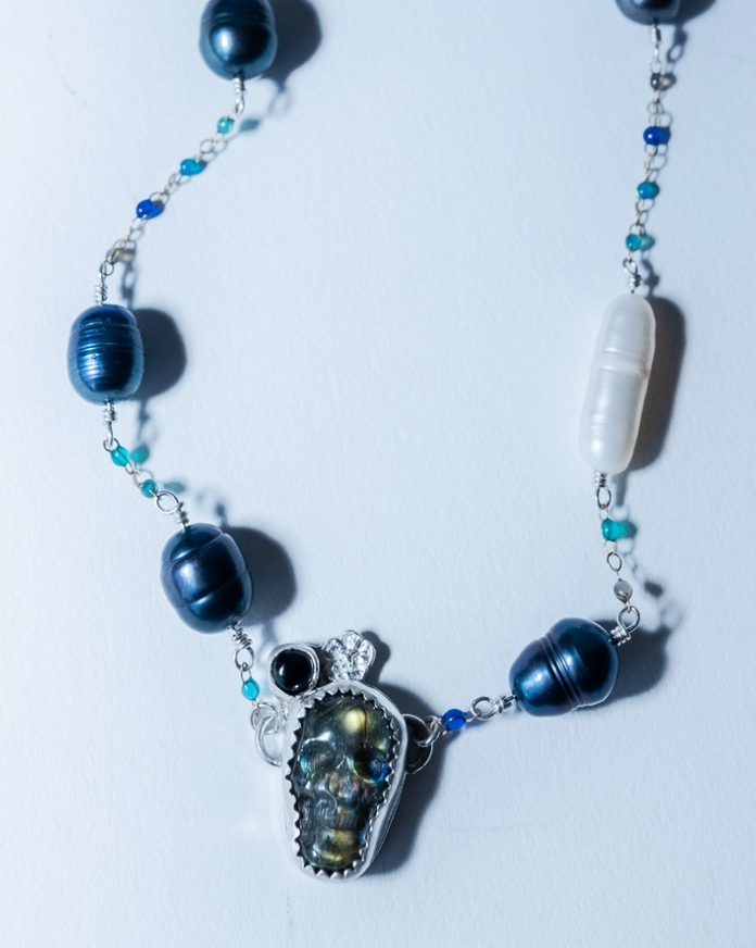 Necklace with blue and black beads on a white background