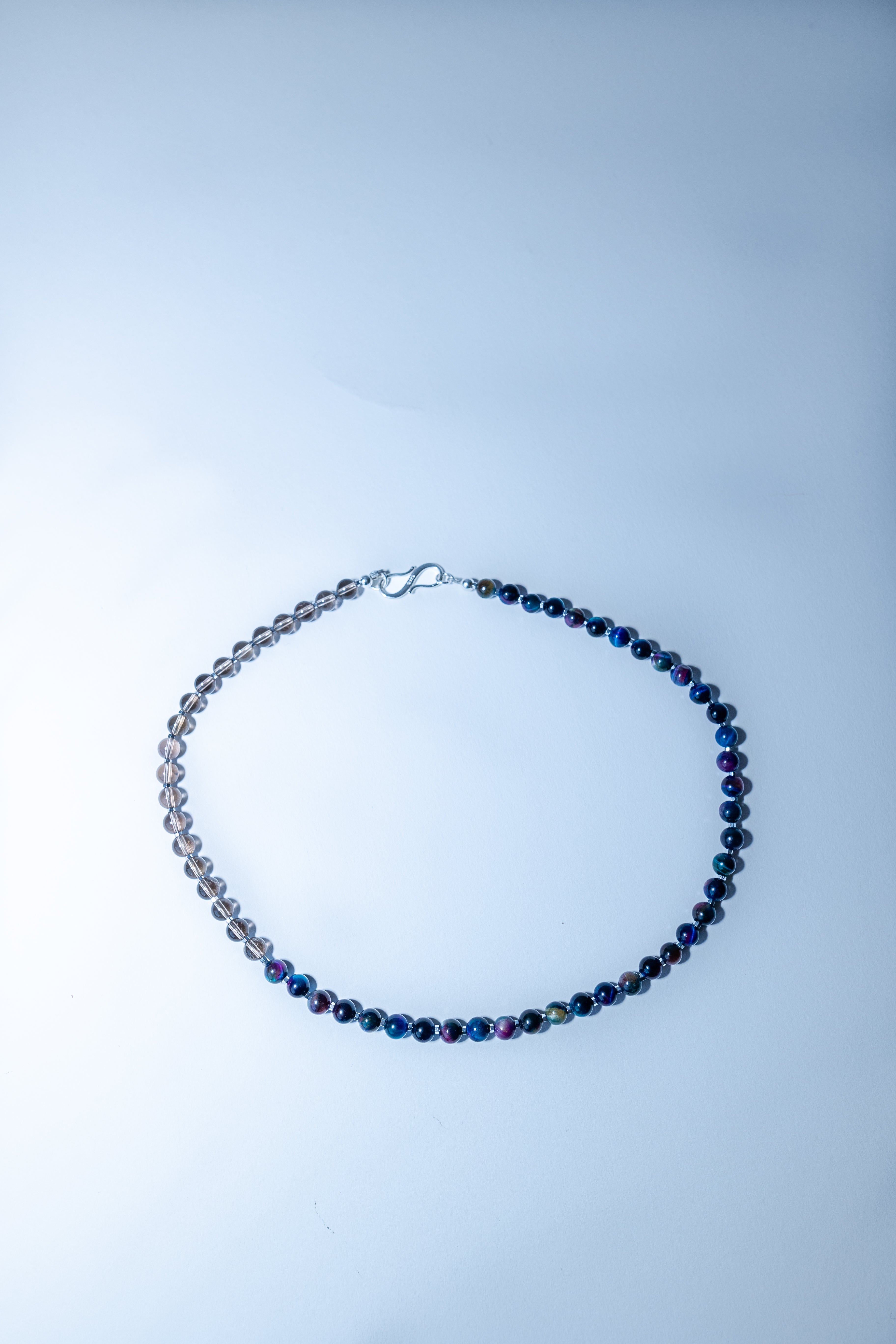 Necklace with blue beads on a light gray background